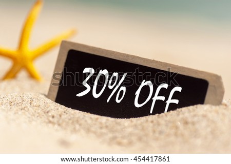 wooden board on sunny sandy beach  with text 30% off