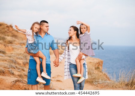 Family walking on the sea shore in sunset, travel photo series