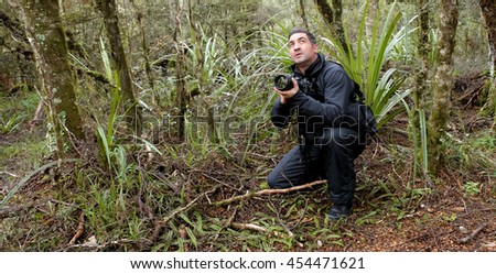 Professional nature, wildlife and travel photographer photographing outdoors during on location photo assignment in Tongariro National Park rain forest, New Zealand. copy space.
