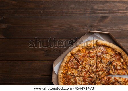 Pizza in a box on a wooden table