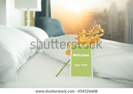 Welcome card placed inside a hotel room bed with Yellow orchid.