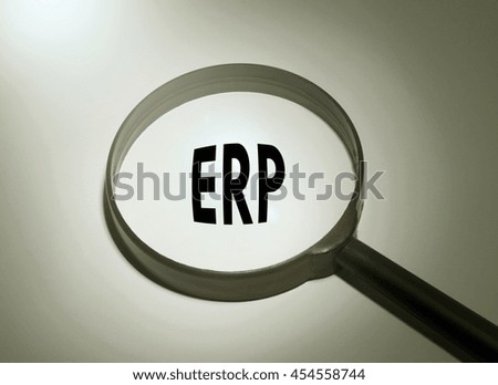 Magnifying glass with the word ERP (Enterprise Resource Planning)