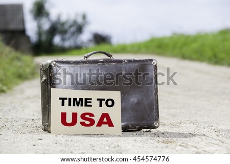Time to USA. Old traveling suitcase on country road