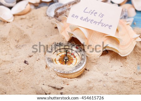 Compass in the sand with Message - Life is an adventure