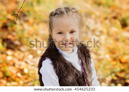 Portrait of a girl in the brown fur vest and a white turtleneck on autumn background