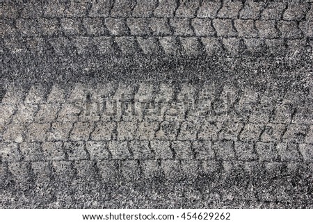 Sand tyre mark on black asphalt texture.