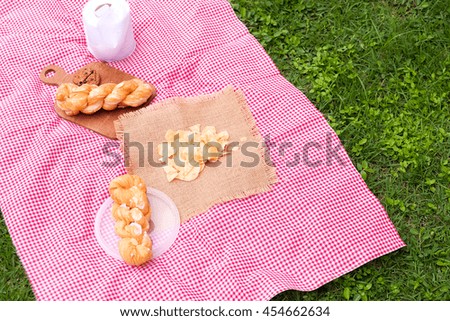 picnic for a summer vacation with freshly baked croissants,snack  and a glass of refreshing soda on the green grass.
