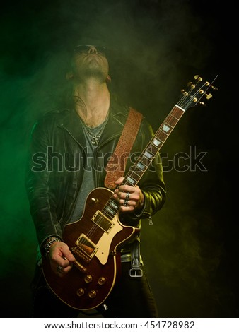 The guitarist plays solo. Close-up. Dark background