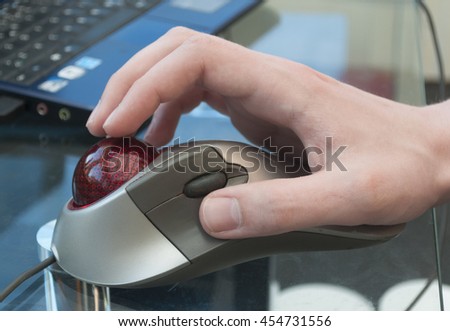 Person using a trackball to control the pointer cursor on a computer Royalty-Free Stock Photo #454731556