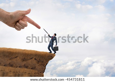business challenge concept businessman pushed to the edge of a cliff Royalty-Free Stock Photo #454731811