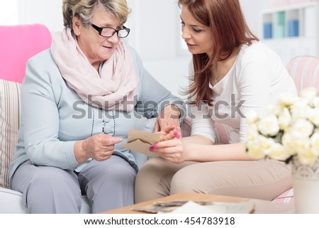 Shot of a senior woman showing old photographs to her daughter