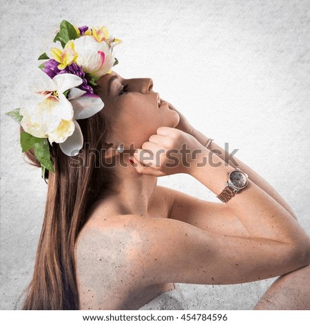 Model woman with crown of flowers over textured background