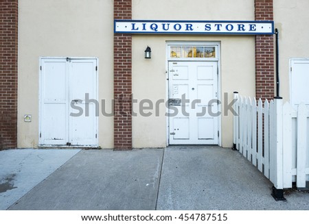 A liquor store sign above the white entrance door.