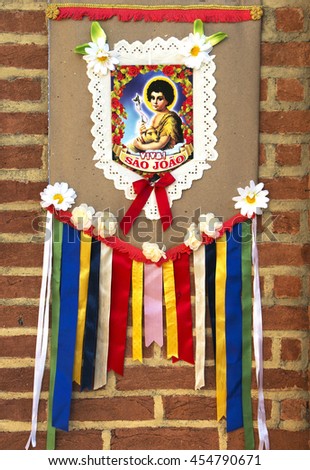 Handmade banner decoration of Juninas Party, a traditional celebration in Brazil. Saint John banner over a brick wall.