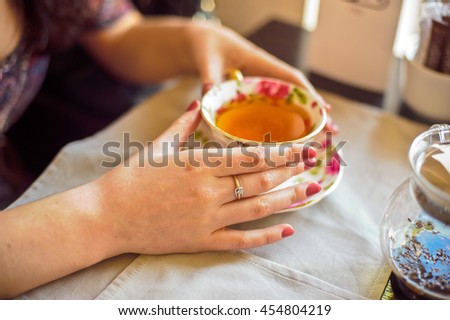 Woman holding a cup of tea with flowers