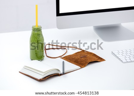 Freelancer work place with detox drink bottle on table. Having smoothie at work.