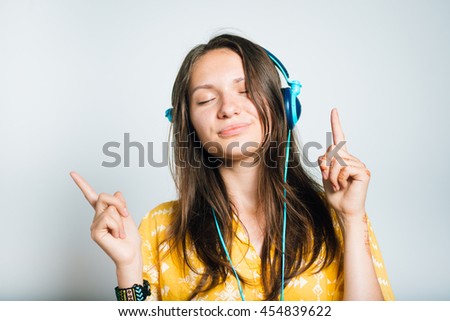 cute girl listening to music or calls with headphones, studio isolated