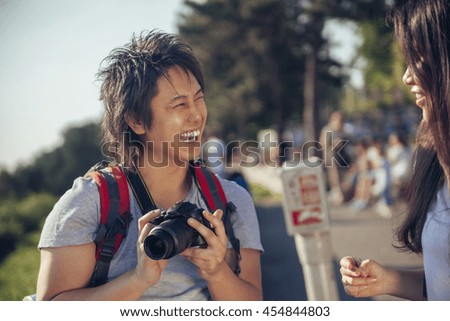 Young Asian Tourists Looking At The Photo