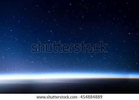 Night sky full of stars and sunrise on the horizon of the Earth on the background. Concept of the space view.