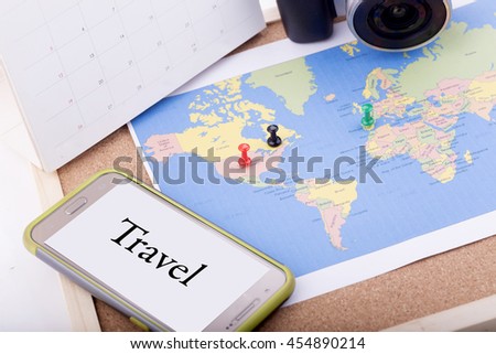 travel concept with maps,camera,smart phone and calendar over wood background