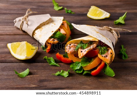 Flat bread with salmon and vegetables on a wooden background. Selective focus.