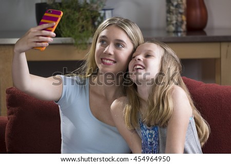 Two girls using a cell phone to take their photo/selfie