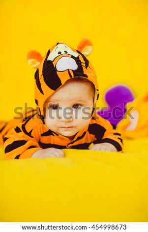 lovely baby  rests on a bright yellow bed