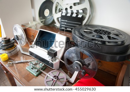 Desktop workspace for vintage movie editing with film reels, editing machine, splice, clapper