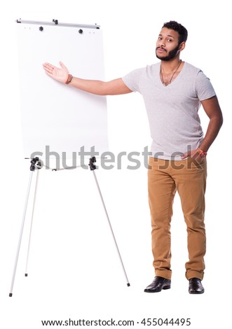 Handsome latino man making a presentation something on white board. Pointing on it with right hand. Full length portrait isolated on white background.