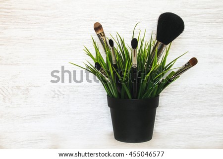 Brushes for cosmetics in the grass on a white background