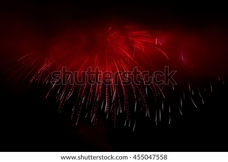 Colorful holiday fireworks in the evening sky with majestic clouds, long exposure