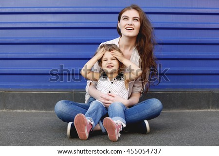 Bright picture of hugging mother and daughter wearing stylish clothes. Happy loving family.