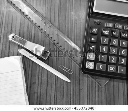 Set of stationery tools:  paper clip, pen,  ruler,  calculator, eraser,paper in:  Black and white sty;e