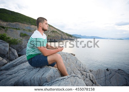 A tourist on the rocks in front of the sea