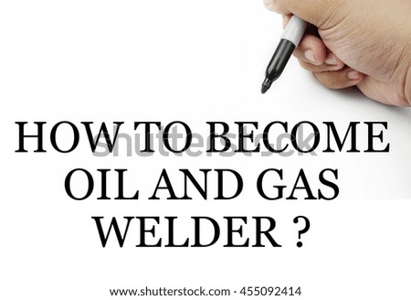 Handwriting " how to become oil and gas welder ? " with the hand and pen isolated in white background.