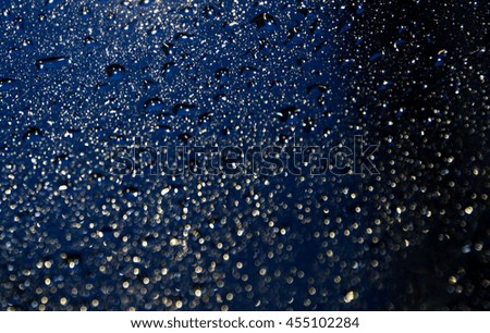 raindrops on the dark surface with narrow dept of field, low key picture.