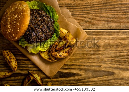 Grilled beef hamburger with potato on wood table