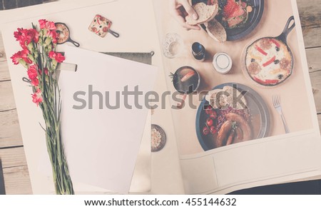 Cute stuff (nut red carnation flower, paper on the stainless tray and mobile phone) on wooden background.craft mock up set with vintage effect and low light. 