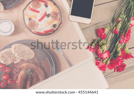 Cute stuff (nut red carnation flower and mobile phone) on wooden background.craft mock up set with vintage effect and low light. 