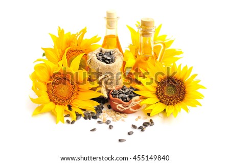 Yellow sunflowers with bottles of oil and a small bag of seeds on a white background