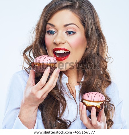 Hungry woman bites cake. Young woman portrait.