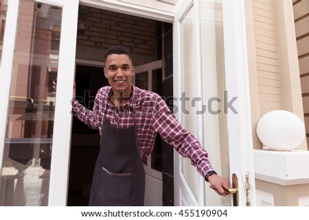Picture of chef from restaurant or cafe looking at camera and happy smiling. Handsome man waiting for guests.