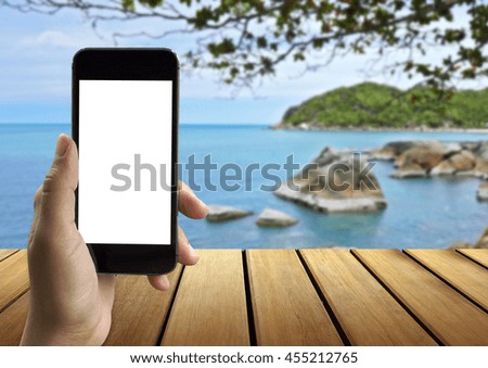 Closeup of women's hands holding cell telephone with empty copy space screen for your advertising text message or promotional content with the beach background.