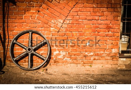 Cartwheel against a brick wall in vintage colors with space for text