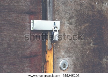 Burglary attempt on a wooden door. The door has a double lock. Image has a vintage effect applied.