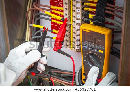 Electrician,Electrician using the digital multimeter to check the resistance and voltage of electric systems in oil and gas industrail. Royalty-Free Stock Photo #455327701