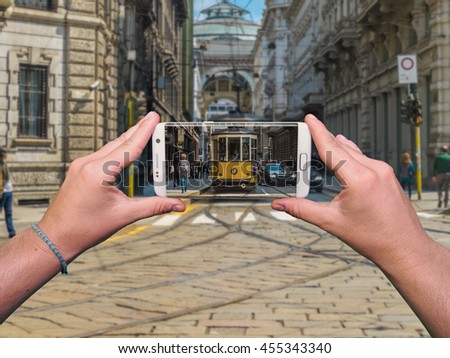 Woman hands taking Milan's trolley photo by white mobile phone
