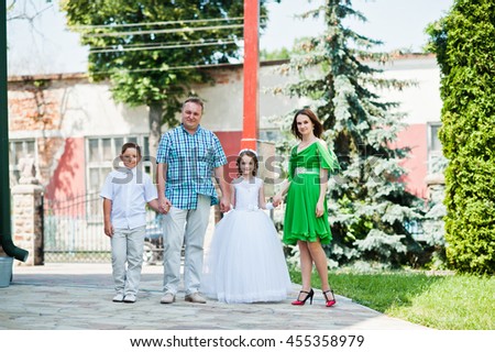 Happy family at first holy communion walking background church cross