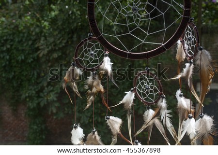 Brown dream catcher with green trees as background Royalty-Free Stock Photo #455367898