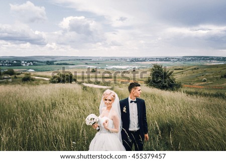 Beautiful wedding couple walking and posing on mountain locations among herbs